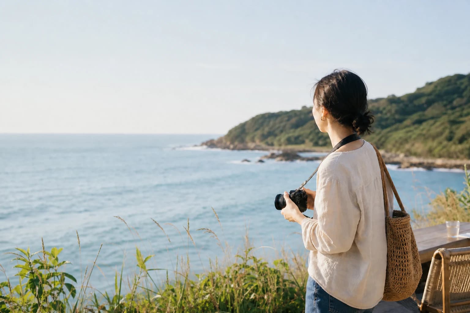 海を眺めながらカメラを持つ旅人を描いた糸島らしい旅の場面